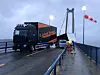 Hengeren til en trailer veltet fredag over en personbil på Bømlabrua. Ingen personer ble skadd i hendelsen. Det er kraftig vind på brua. Foto: Politiet / NTB