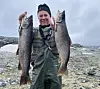 Anleggsveteranen Morten Wangen har høyfjellsfiske som hobby. Her med to store rugger fisket på et høytliggende vatn i Jotounheimen. Foto: Privat