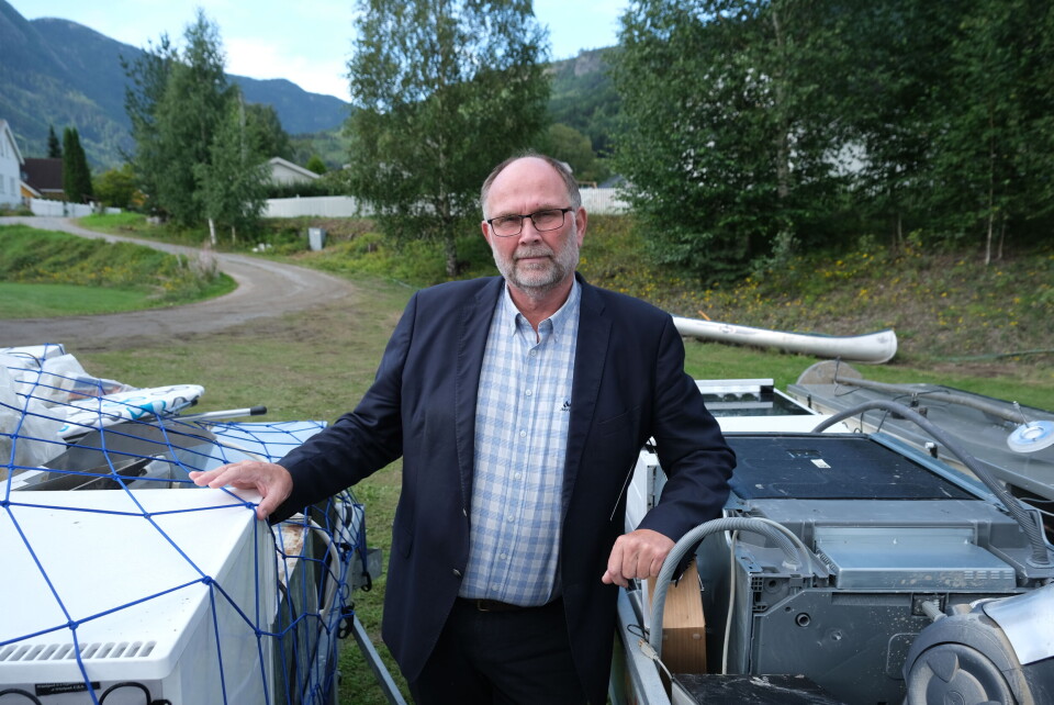 Ordfører i Nesbyen, Tore Haraldset, holder på to tilhengere som er fylt opp med ødelagte ting etter flommen. Foto: Marius Lysø
