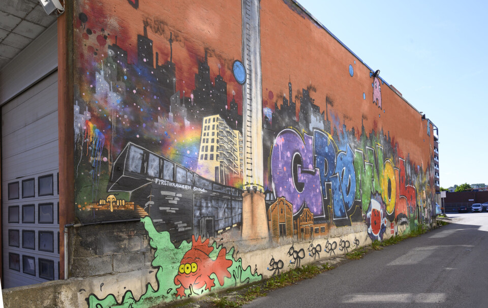 GRAFITTI. Tobias’ kompis Halvor Harsem, også kjent som gateartisten Kong Halvor, har malt et digert grafittimaleri på fasaden ved inngangspartiet til Oslo Street Fotball Senter. Her er det hentet elementer fra nærmiljøet, med blant annet referanser til Fyrstikktorget. Foto: Trond Joelson