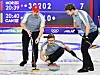 Tre norske curlingspillere sender en stein nedover isen under OL-kamp mot Canada.