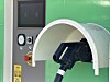Elbillader med kontakt under hvit bue og kontrollpanel ved siden av. Elektrisk maskin