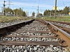 Lav vinkel langs doble jernbanespor omgitt av gress og trær