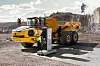Gul Volvo-dumper står parkert ved en ladestasjon i et steinbrudd.