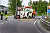 Veltet betongbil ligger på siden i en rundkjøring, med personer i refleksklær og sperringer rundt.