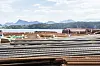 Stablede stålstenger og armeringsjern utendørs med fjell i bakgrunnen.