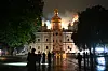 En katedral i Kyiv står i brann om natten, med flammer på taket og folk som ser på på avstand.