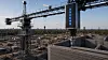 Tårnkran ved et byggeområde med store betongvegger og åpen himmel.
