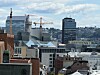 Utsikt over en by med flere kontorbygg, byggekraner og en tett skyline.