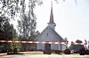 Stensgård kirke med avsperring foran inngangen og trær rundt bygningen.