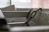 Nærbilde av stablede metallvogner med håndtak i et lager.