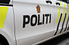 Nærbilde av siden på en hvit politibil med teksten «POLITI» og gule markeringer.