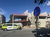 Politibil parkert foran en byggeplass med en blå og rød trafikkskiltstolpe i forgrunnen.