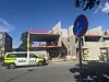 Politibil parkert foran en byggeplass med en blå og rød trafikkskiltstolpe i forgrunnen.
