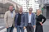 Fire voksne personer står samlet på en gate i Oslo, med bygninger og trafikkskilt i bakgrunnen.
