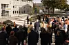 En folkemengde samles ved en gangbru mellom universitetsbygninger.