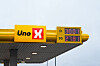 Uno-X-skilt med digitale priser på bensin og diesel mot en lys himmel.