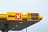 Uno-X-skilt med digitale priser på bensin og diesel mot en lys himmel.