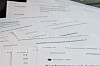 Nærbilde av flere norske anbudsdokumenter med overskriften «Resultat» på et bord.